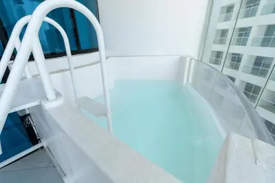 a hospital room with a hot tub on a building at Ahlan HH - Exclusive 2-BR Apartment in Opalz by Danube - Balcony with Mini Pool in Dubai