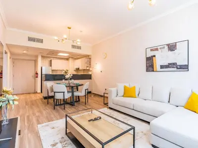 a living room with a white couch and a table at Spacious 1BR-Walk to Dubai Mall & Khalifa-Downtown Dubai in Dubai