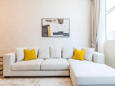 a living room with a white couch with yellow pillows at Spacious 1BR-Walk to Dubai Mall & Khalifa-Downtown Dubai in Dubai