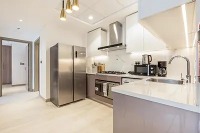 a kitchen with a stainless steel refrigerator and a sink at Urban Family Home minutes from Downtown in Dubai