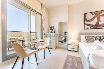 a bedroom with a bed and a table and chairs at Steps from Dubai Hills Park, Walk to Dubai Hills Mall, 15-Minute Drive to Burj Khalifa and Dubai Mall, Sway Residences, Dubai Hills by Deluxe Holiday Homes in Dubai