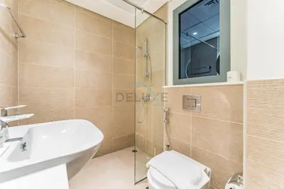 a bathroom with a shower and a toilet and a sink at Steps from Dubai Hills Park, Walk to Dubai Hills Mall, 15-Minute Drive to Burj Khalifa and Dubai Mall, Sway Residences, Dubai Hills by Deluxe Holiday Homes in Dubai