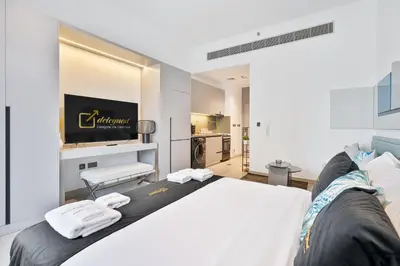 a bedroom with a large bed with towels on it at Posh Studio in MBR by Deleguest in Dubai