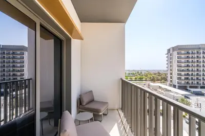 a balcony with a chair and a view of a city at Posh Studio in MBR by Deleguest in Dubai