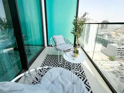 a balcony with two chairs and a table on a building at Lavish Studio Apt in Binghatti Azure - Pool & Gym in Dubai