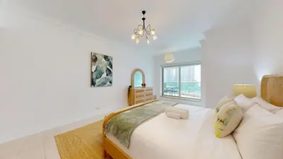 a white bedroom with a bed and a window at Al Mesk Tower - One Bed with Scenic Marina Views in Dubai