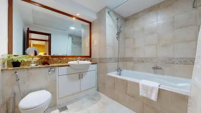 a bathroom with a toilet and a sink and a tub at Al Mesk Tower - One Bed with Scenic Marina Views in Dubai