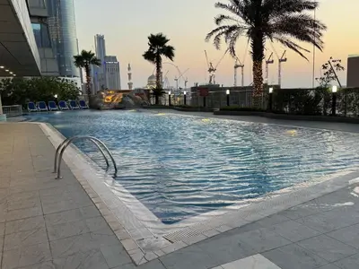 a large swimming pool in a city with palm trees at Luxury 2 BHK in Ocean Heights at Dubai Marina Living with Stunning Views in Dubai