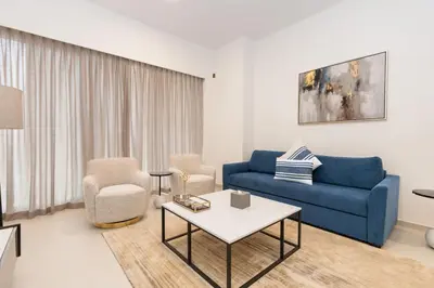 a living room with a blue couch and chairs at CitiHome Stylish 1BR Grande in Dubai
