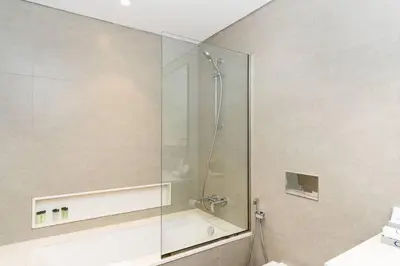 a bathroom with a shower with a glass door at CitiHome Stylish 1BR Grande in Dubai