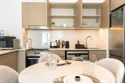 a kitchen with a table and chairs with glasses on it at CitiHome Stylish 1BR Grande in Dubai