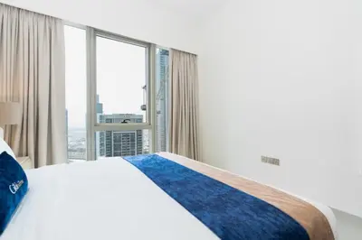 a bedroom with a bed and a large window at CitiHome Stylish 1BR Grande in Dubai