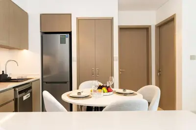 a kitchen with a table and chairs and a refrigerator at CitiHome Stylish 1BR Grande in Dubai