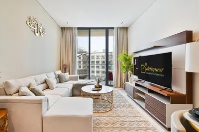a living room with a couch and a tv at 2BR Homely Apartment in Arjan in Dubai