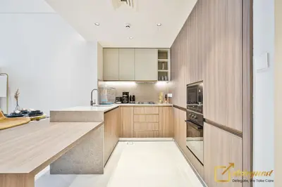 a kitchen with wooden cabinets and a counter top at 2BR Homely Apartment in Arjan in Dubai