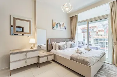 a bedroom with a bed and a large window at Stylish 2 BR Business Bay - Canal View - Gym and Pool in Dubai