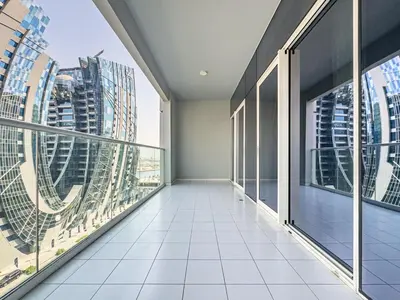 a balcony with large windows and a view of a city at Stylish 2 BR Business Bay - Canal View - Gym and Pool in Dubai