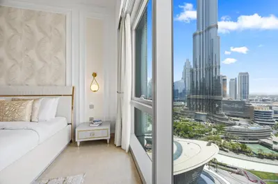 a bedroom with a large window with a view of a city at Burj Khalifa and Dubai Fountian Direct View - Luxury 2BR Flat - Downtown Dubai in Dubai