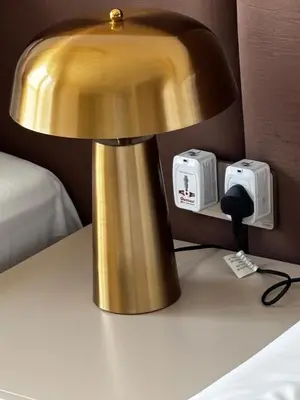 a gold lamp on a table next to a bed at Burj Khalifa and Dubai Fountian Direct View - Luxury 2BR Flat - Downtown Dubai in Dubai
