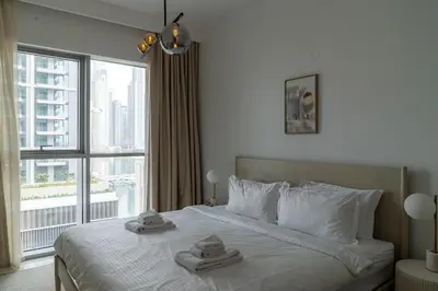 a bedroom with a large bed with towels on it at Seaside Bliss Chic 1BR with Balcony, Pool & Gym in Dubai