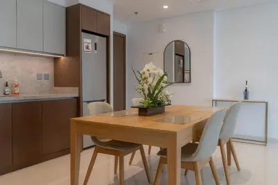 a kitchen and dining room with a wooden table and chairs at Seaside Bliss Chic 1BR with Balcony, Pool & Gym in Dubai