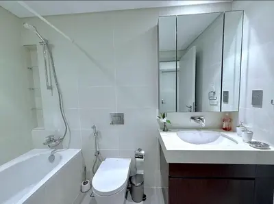 a bathroom with a sink and a toilet and a bath tub at Seaside Bliss Chic 1BR with Balcony, Pool & Gym in Dubai