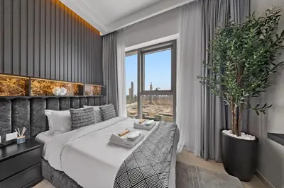 a bedroom with a large bed and a large window at Burj View Chic 2BR Downtown Dubai in Dubai