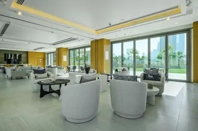 a lobby with white chairs and tables and windows at Burj View Chic 2BR Downtown Dubai in Dubai