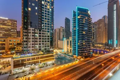 a city skyline with buildings and traffic at night at Stylish 1BR - Pool, Gym Access & City Skyline Views near JBR Beach in Dubai