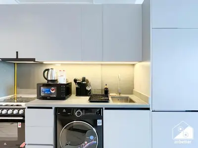 a kitchen with a washing machine and a microwave at Luxury Studio in MAG City l Private Balcony in Dubai