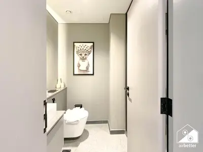 a bathroom with a toilet and a picture on the wall at Modern Studio Retreat l MAG l Parking & WI-FI in Dubai