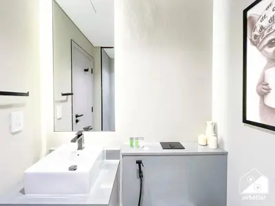 a white bathroom with a sink and a mirror at Modern Studio Retreat l MAG l Parking & WI-FI in Dubai