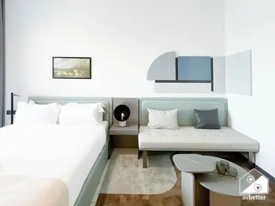 a bedroom with a bed and a desk and a table at Stylish Studio Living l MAG Meydan in Dubai