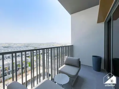 a room with a chair and a balcony with a view at Stylish Studio Living l MAG Meydan in Dubai