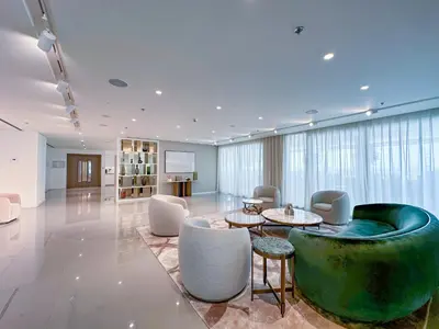 a lobby with a green couch and tables and chairs at Luxe 2 bedroom Apartment full Sea and Palm Views in Dubai