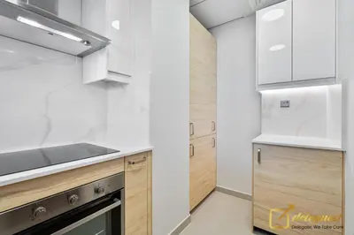 a kitchen with white appliances and wooden cabinets at Majestic 3BR Villa in DH2 by Deleguest in Dubai