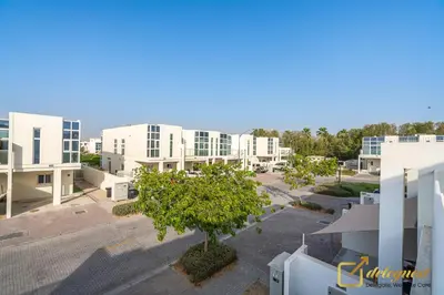 an apartment complex with a tree in a parking lot at Majestic 3BR Villa in DH2 by Deleguest in Dubai