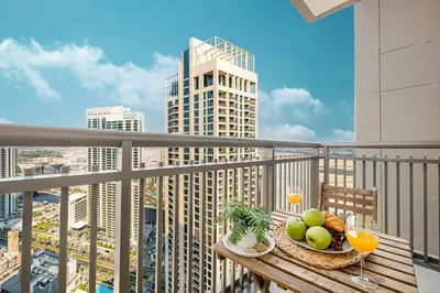 a table with a plate of fruit and drinks on a balcony at Modern Creekside 1BR Near Dubai Mall & Downtown in Dubai