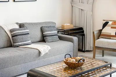 a living room with a couch and a table at Modern Creekside 1BR Near Dubai Mall & Downtown in Dubai