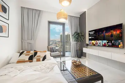 a bedroom with a bed and a flat screen tv at Modern Creekside 1BR Near Dubai Mall & Downtown in Dubai