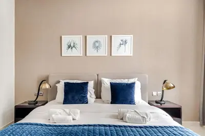a bedroom with a large bed with three pictures on the wall at Stylish 1BR with Burj & Canal View in Dubai