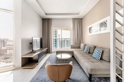 a living room with a couch and a tv at Stylish 1BR with Burj & Canal View in Dubai
