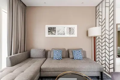 a living room with a couch with blue pillows at Stylish 1BR with Burj & Canal View in Dubai