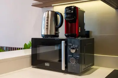 a coffee maker sitting on top of a microwave at Luxury JLT Studio Renovated Lake View Metro in Dubai