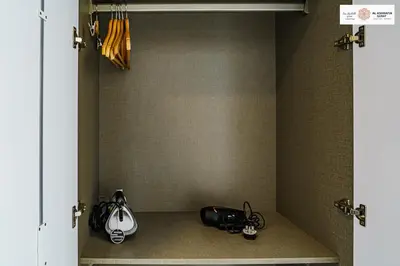 a walk in closet with umbrellas and shoes in it at Serenity 1 bdr with private garden in Dubai