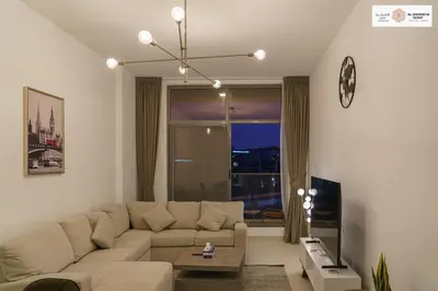 a living room with a couch and a large window at Serenity 1 bdr with private garden in Dubai