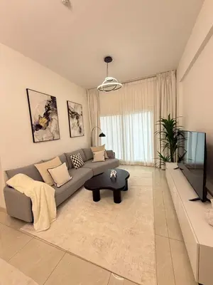 a living room with a couch and a tv at Premium 1BR, 2 Bath, Walk to Circle Mall, Pool & Gym in Dubai