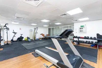 a gym with a treadmill and lots of exercise equipment at Premium 1BR, 2 Bath, Walk to Circle Mall, Pool & Gym in Dubai