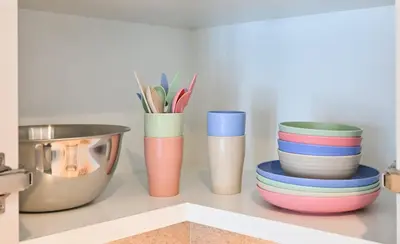 a shelf with colorful cups and plates on it at BEST Burj Khalifa View 2br 3 beds in Dubai
