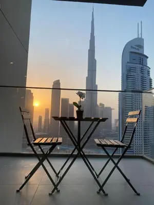 a table and chairs on a balcony with a view of a city at BEST Burj Khalifa View 2br 3 beds in Dubai